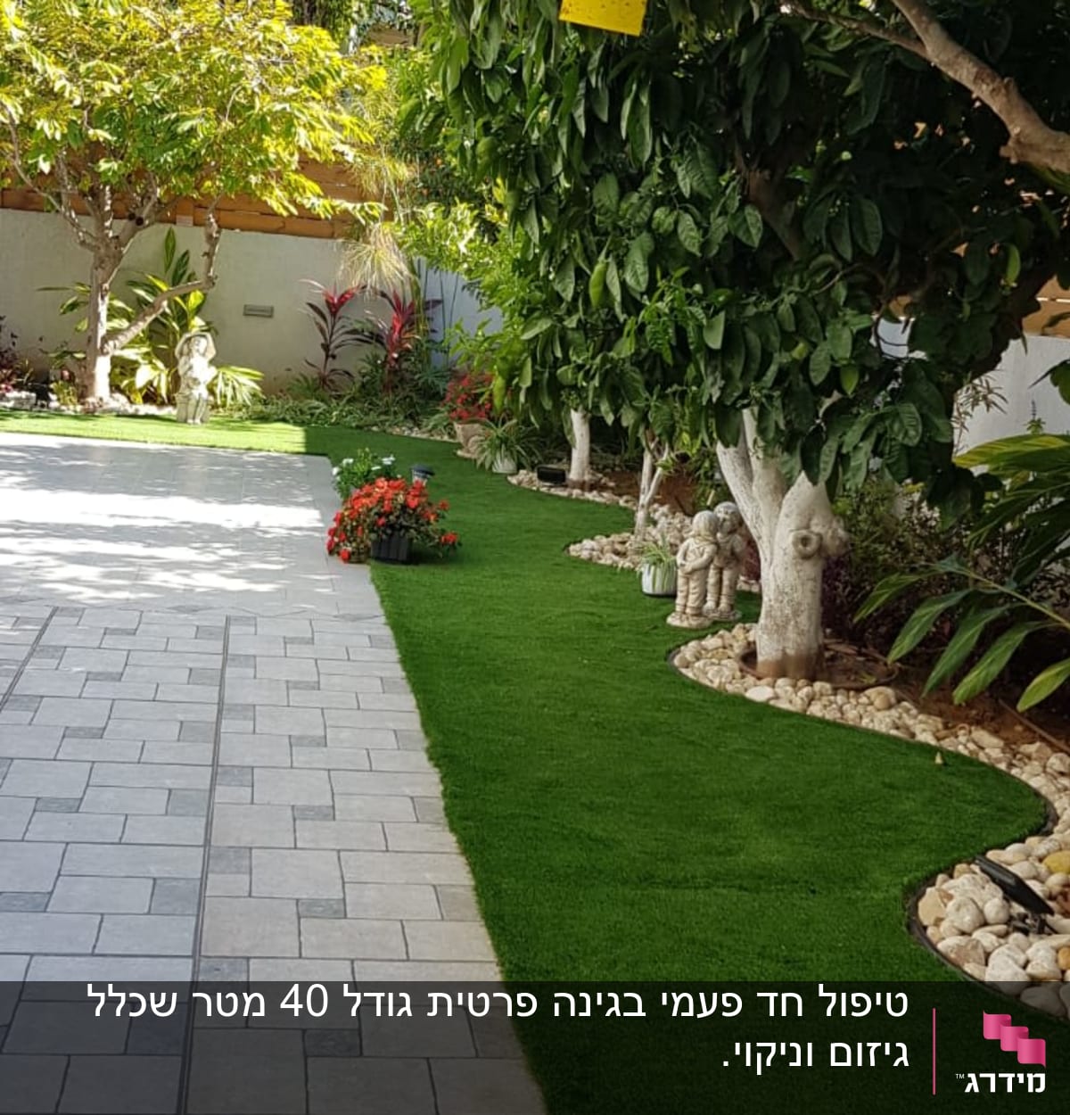 עצים עם דשא מלאכותי ופרחים בגינה מטופחת